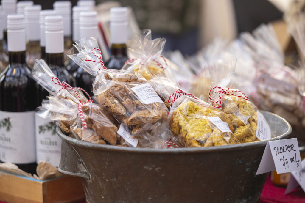 Vackert inslagna skorpor till försäljning på Stora Sköndals julmarknad, flaskor av glögg i bakgrunden.