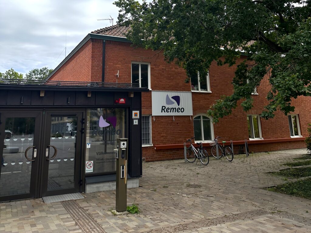 Röd tegelbyggnad med banderoll med ordet "Remeo" på.